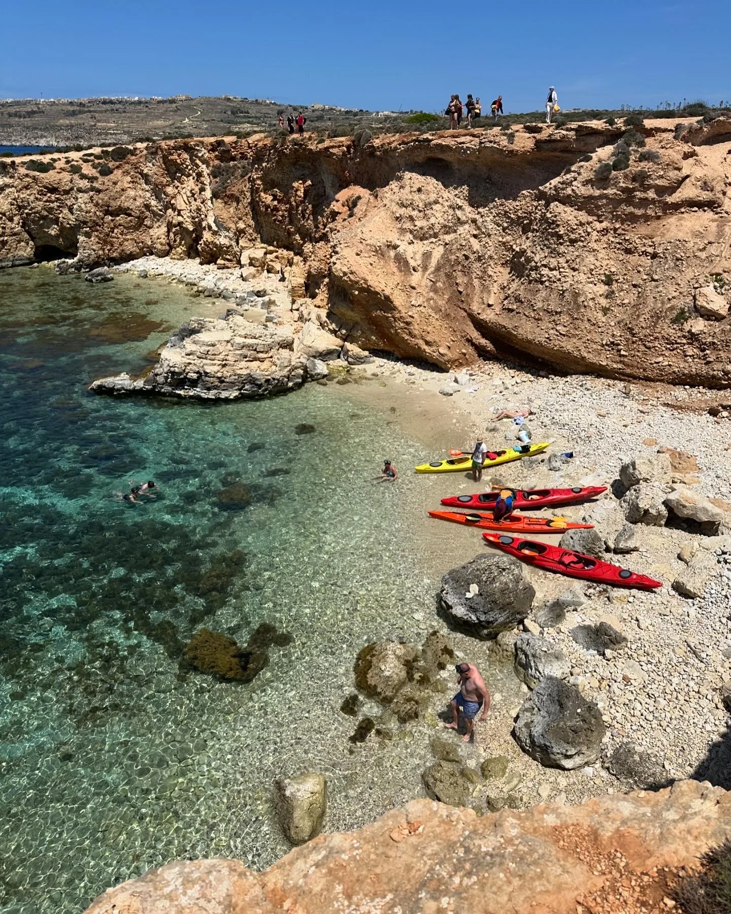 Kayaks on a clear Mediterranean shoreline